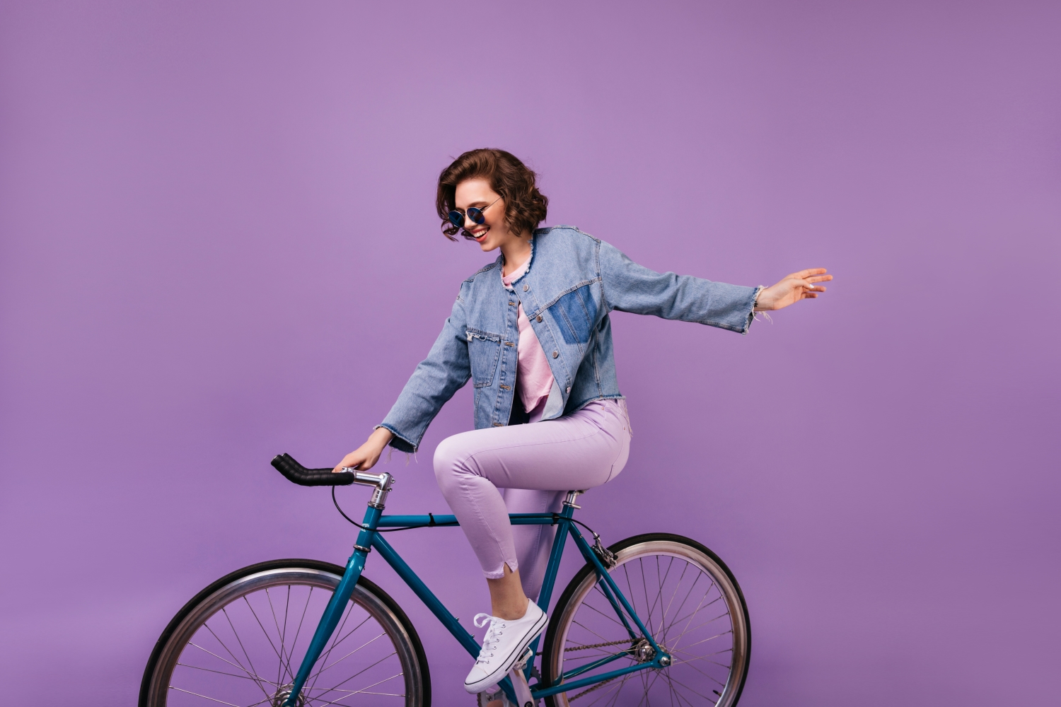 Persona in bici su sfondo viola